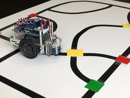 A view of the ActivityBot 360 next to a yellow marker on the line-follow track.