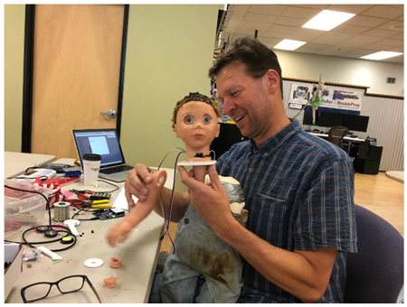 Parallax CEO Ken Gracey figuring out how to get the head back onto the Spooky Doll body.