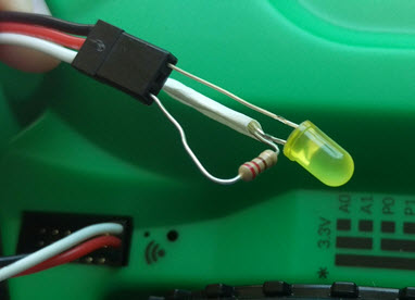 Image showing an LED and connected resistor plugged into a 3-pin cable, which is plugged into P5 on the Hacker Port.
